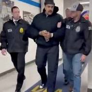 Maduro na záběru z videa, na kterém ho členové DEA přivádí k úředním úkonům. Záběry zveřejnil Bílý dům, Maduro na nich lidem okolo přeje šťastný nový rok.