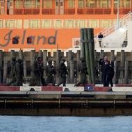 Ještě v sobotu ho Američané dovezli do Spojených států. Už tehdy ho doprovázelo velké množství ozbrojených příslušníků amerických bezpečnostních složek, nejinak tomu bylo v pondělí cestou k newyorskému soudu. Opět ho převáželi v poutech.