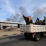 Auta projíždějí po dálnici kolem poškozené části přístavu La Guaira, který se stal jedním z cílů amerického útoku.