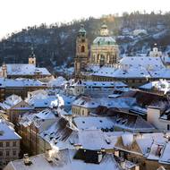 Zasněžená Malá Strana, chrám sv. Mikuláše a Petřínské sady.