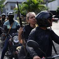 Členové Cuadrantes de la Paz stojí ve frontě na natankování paliva v okolí přístavu La Guaira. 