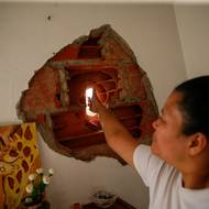 Venezuelské úřady ale oficiálně počty obětí nekomentovaly. 
(Žena ukazuje díru ve svém domě po útoku USA na Venezuelu. Caracas, Venezuela, 4. ledna.)