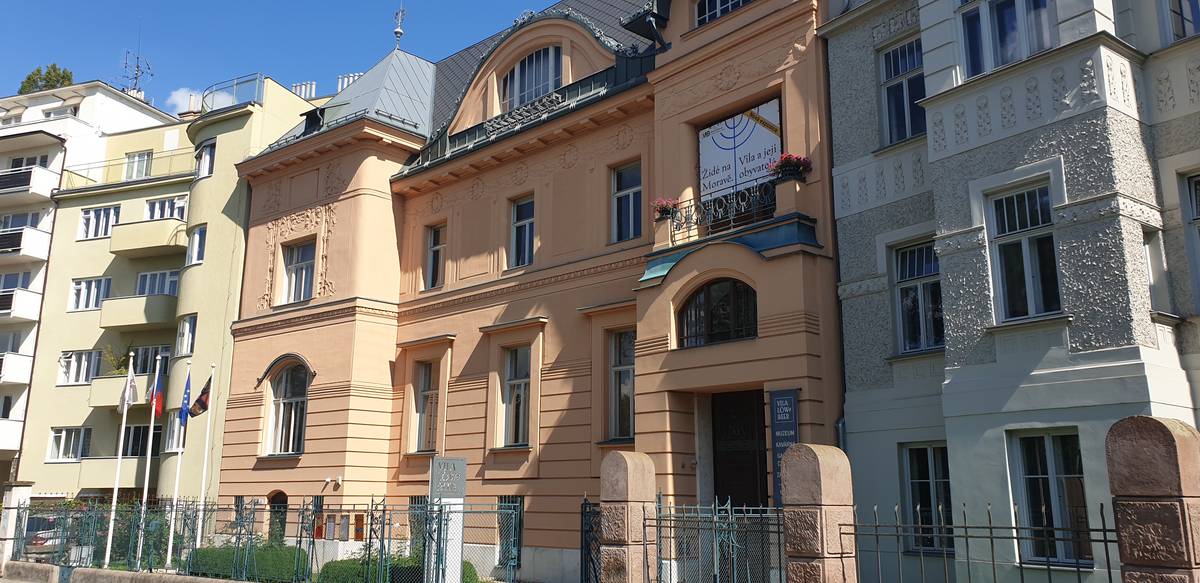 Vila je v ulici vměstnaná mezi bytové domy.