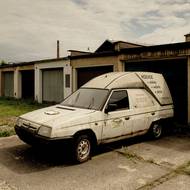 Škoda Forman Plus zaparkovaná mezi garážemi na předměstí Mnichova Hradiště. Architektura typická pro období socialismu.