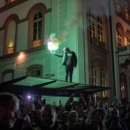 Skupina studentů ušla z univerzity v Novém Pazaru více než 400 km, aby se připojila k jedné z největších a nejdelších protestních akcí v zemi za poslední desetiletí, kterou vyvolal pád střechy nádraží o rok dříve. (Vítání studentů z Nového Pazaru při jejich příjezdu do Bělehradu, 28. října 2025.)