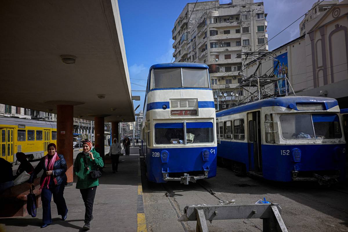 Linka s dvoupatrovými modrými vozy byla zprovozněna v době rozvoje kosmopolitní metropole, která tehdy hostila významnou evropskou komunitu. V Alexandrii je jeden z mála tramvajových systémů na světě, který používá dvoupatrové vozy – dalšími příklady jsou anglický Blackpool a Hongkong. (Cestující kráčejí po nástupišti tramvajové zastávky v Alexandrii, 18. února 2026.)