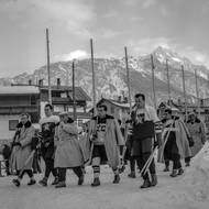 Výjev doslova z jiného sportovního století: českoslovenští hokejisté kráčejí na stadion v Cortině pěšky, s dresy schovanými pod silnými kabáty.