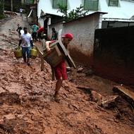 Lidé vynášejí věci z postižených domů.