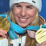 Pjonchčchang 2018: U nejtěžších medailí historie, které Ester Ledecká vyhrála hned dvě - za snowboard a za superobří slalom na lyžích, se korejský designér Sukwoo Lee inspiroval svazkem stonků rostlin – jako kdyby placky vyřízl z bambusové rohože. Jejich rozložení vychází i z korejské abecedy a dynamicky „poškrábaný“ vzhled má odkazovat na úsilí a vytrvalost sportovců. Součástí byla i stuha z tradiční jihokorejské látky.