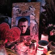 Před ruskou ambasádou vzniklo také místo s fotkou Alexeje Navalného, kam lidé pokládali květiny a svíčky. 