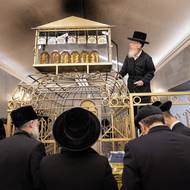 Rabín Simcha Krakowski, který patří k hlavním organizátorům poutí do Leżajska a Lelówa, klade nad hrob cadika Elimelecha nádobu s olejem pro pamětní světlo.