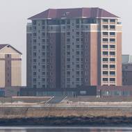 Dva severokorejští vojáci se procházejí kolem nově postavených budov ve čtvrti Hadan v severokorejském Sinuidžu, 11. března.