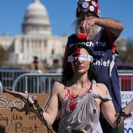 Účastnici demonstrace Sam Scarcello, oblečené v kostýmu, vylévají na hlavu umělou krev ve Washingtonu D.C.