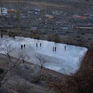 Letos organizátoři připravili kluziště jako vždy: v noci polévali vodou a ručně vyhlazovali povrch.

(Místí i hráči si prohlížejí nedokončené umělé kluziště, které bylo postaveno poté, co přírodní jezera zamrzla později než obvykle, 11. ledna ve vesnici Sost.)