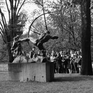 Návštěvníci s historikem umění Jaromírem Homolkou před sochou Hérakla od Émila-Antoina Bourdella v zahradě Šternberského paláce, 1959.