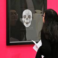 Návštěvnice výstavy si prohlíží serigrafii Diamond Skull od Damiena Hirsta.