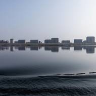 Budovy ve čtvrti Hadan v severokorejském Sinuidžu podél řeky Jalu. Podle satelitních snímků jde o novou zástavbu. Vyfoceno 15. ledna 2026 z čínského Tan-tungu.