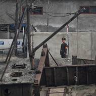 Severokorejský voják stojí na stráži u člunů na břehu řeky Jalu, 24. března.