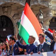 Peter Magyar drží v ruce vlajku země.