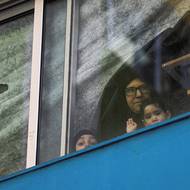 Žena a děti se dívají z okna školy, kde našli dočasnou střechu nad hlavou, 11. března v Bejrútu.  