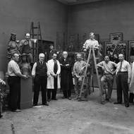 Příprava expozice Společnosti vlasteneckých přátel umění v Městské knihovně za přítomnosti jejího ředitele Vincence Kramáře, 30. léta 20. století.