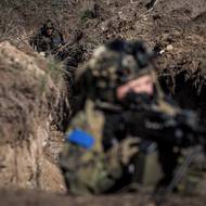 Voják s kulometem hlídá jeden z vchodů do zákopů.