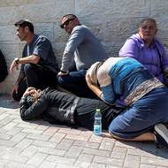 Smuteční hosté se schovávají za zvuku sirén na pohřbu na hřbitově ve městě Bejt Šemeš. (2. března)