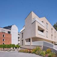 Žitný mlýn Boršov dnes. Druhá novostavba má na fasádách stejné světlé cihelné pásky jako nástavba historické budovy sila.