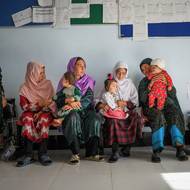 Škrty vedly k pozastavení činnosti nebo uzavření 422 zdravotnických zařízení po celé zemi, včetně malých komunitních klinik, kde pracuje pouze jedna porodní asistentka. Lidé v mnoha těchto zařízeních pracují bez platu a bez zásob.

(Ženy čekají na Gulshaman, jedinou porodní asistentku v rodinném zdravotním středisku ve Warasu, která pracuje, aniž by dostávala plat. Provincie Dájkundí, Afghánistán, 20. července 2025.)