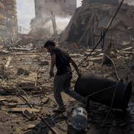 Ještě ve středu IDF oznámily, že během 24 hodin zasáhly 200 cílů, které byly podle nich spojené s Hizballáhem. (Muž táhne sud na místě izraelského útoku v libanonském Tyru, 8. dubna.)