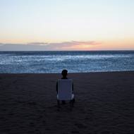 Turista pozoruje východ slunce na pláži v Barceloně ve Španělsku, 12. dubna.