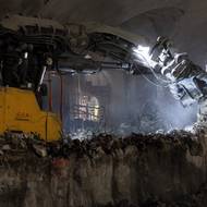 Stroj odstraňuje primární ostění dílčího výrubu. Celá stanice se razila celkem na 11 dílčích výrubů. Za strojem je eskalátorový tunel do budovy Gemini. 