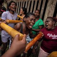 Fiesta de los Manacillos je tradiční rituál, který komunita pořádá během aktivit Svatého týdne a který spojuje katolicismus s africkými duchovními tradicemi. Pro diasporu jde o pomyslný návrat domů, který představuje hluboké potvrzení jejich kulturní odolnosti. (Mercedita a další zpívají tradiční písně během obcházení domů. Zpěv navozuje transový stav, který vyvolává přítomnost předků. 30. března 2024.)