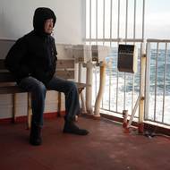 Vlnění moře a ledu nese něco magického, ale ne pro Ludviga Larsena. Nudil se. (Muž se dívá se na moře z paluby trajektu Sarfaq Ittuk nedaleko města Maniitsoq, 13. března 2026.)