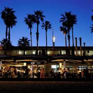 Že právě Španělsko na válce vydělává, může působit trochu paradoxně. Madrid patří v Evropě mezi nejhlasitější kritiky americko-izraelské války proti Íránu, americký prezident Donald Trump kvůli tomu ostře kritizoval španělského premiéra Pedra Sáncheze. Hrozil například úplným přerušením obchodních vztahů se Španělskem.

(Lidé ve venkovních restauracích podél pobřeží v Barceloně, 5. dubna.)