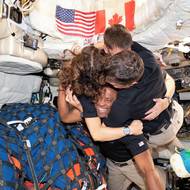 K Měsíci dosud mířilo 24 astronautů, z nichž se 12 prošlo po lunárním povrchu. (Christina Kochová, Jeremy Hansen, velitel Reid Wiseman a pilot Victor Glover se objímají na cestě domů po průletu kolem odvrácené strany Měsíce, 7. dubna 2026.)