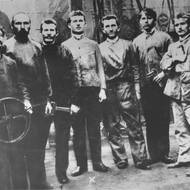 Tomáš Baťa (pátý zleva) s bratrem Antonínem (čtvrtý zleva) s pracovníky ve strojírně, 1906.