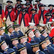 Američtí vojáci v historických kostýmech očekávají příjezd britského královského páru.