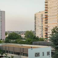 Místní žena Ysnear sedí na střeše základní školy École élémentaire Paul Langevin na sídlišti La Zup. 19. července 2023 ve Fontenay-sous-Bois.