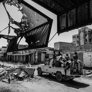 Zatímco se šíří hladomor a hroutí se základní služby, zahraniční mocnosti konflikt nadále podněcují dodávkami zbraní. (Skupina vojáků prochází poškozeným tržištěm ve druhém nejlidnatějším městě Omdurmánu, kde od dubna 2023 probíhají neustálé boje. 25. října 2024.)