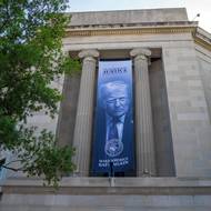 Americký prezident Donald Trump výrazně přetváří podobu Washingtonu D.C. A to nejen prostřednictvím stavebních úprav, ale i symbolicky. Podle BBC se jeho jméno stále častěji objevuje na významných institucích a jeho podobizna je viditelná na různých místech. (Budova ministerstva spravedlnosti. Vyfoceno 15. května 2026.)