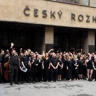 V černém protestovali také zaměstnanci Českého rozhlasu. Po poledni se jich zhruba stovka na několik minut shromáždila před hlavním vchodem, kde zazněla fanfára v podání členů Symfonického orchestru Českého rozhlasu.