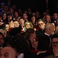 Eben využívá příležitosti a zdraví hollywoodské hvězdy Kevina Bacona s Kyrou Sedgwick a jejich syna Travise, kteří sedí v hledišti.